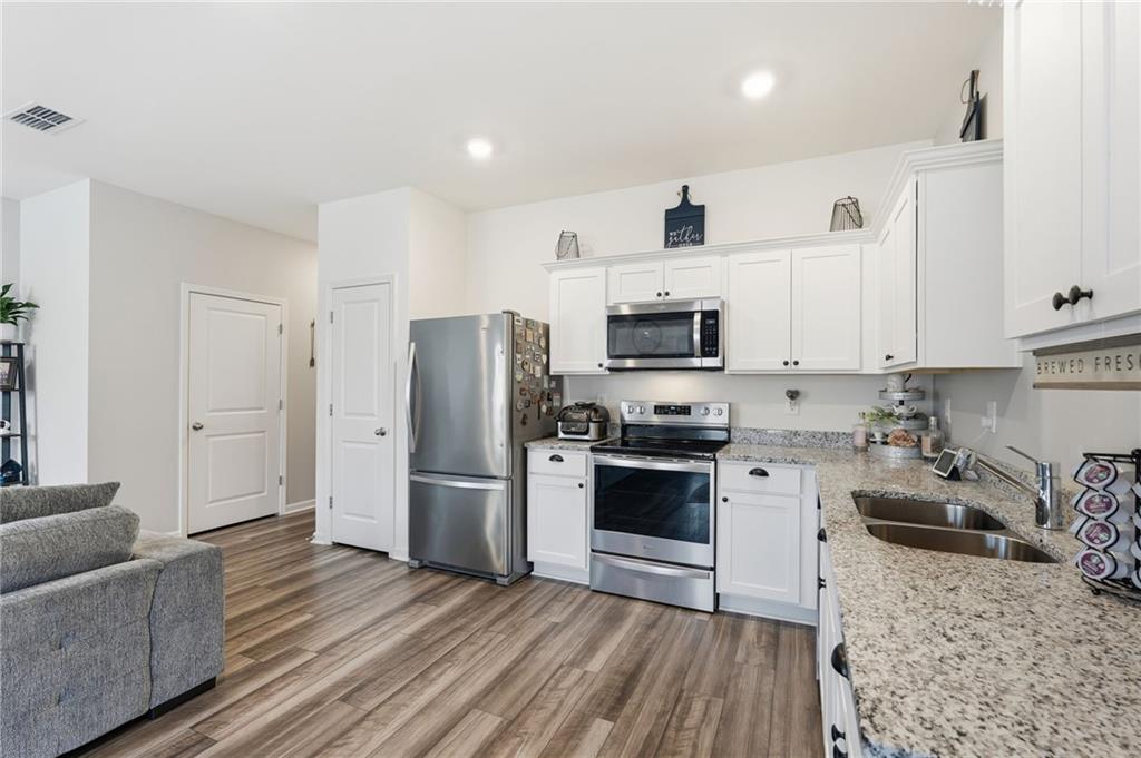 60 Thetford Way Winder, GA 30680 - Photo 4 of 34 a kitchen with stainless steel appliances granite countertop a refrigerator stove microwave and sink