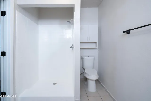 a bathroom with a granite countertop toilet and a sink