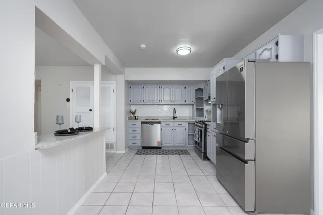 a kitchen with a refrigerator sink and cabinets