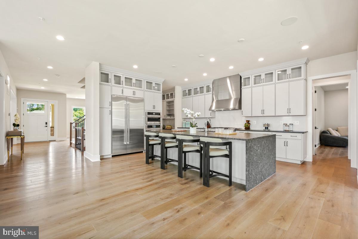 12321 Potomac Hunt Road North Potomac, MD 20878 - Photo 14 of 64 a kitchen with stainless steel appliances kitchen island granite countertop a refrigerator a stove a sink a dining table and chairs with wooden floor