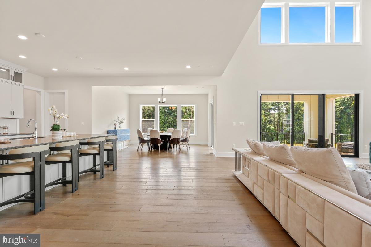 12321 Potomac Hunt Road North Potomac, MD 20878 - Photo 15 of 64 a large dining hall with stainless steel appliances granite countertop a living room and couches with wooden floor