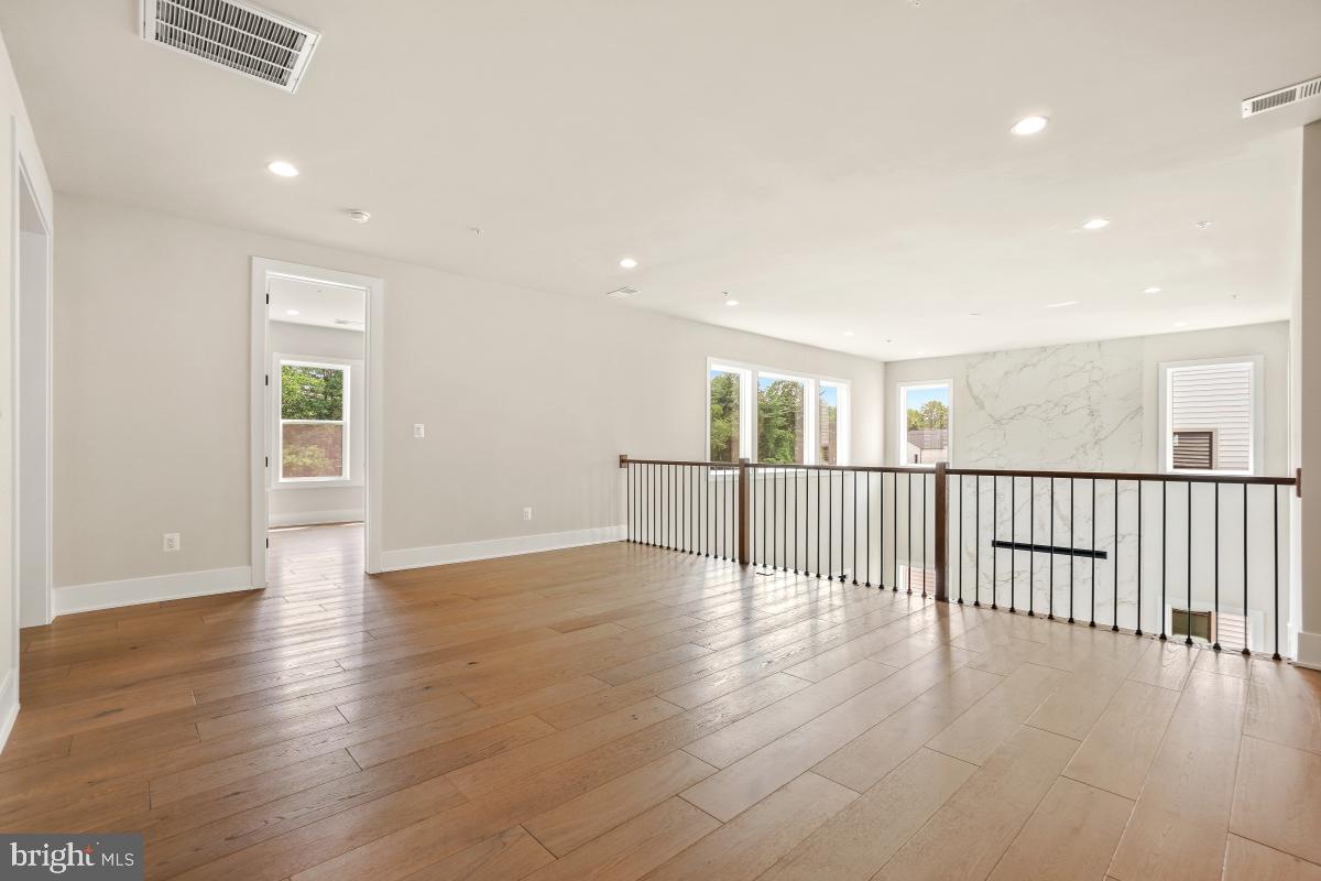 12321 Potomac Hunt Road North Potomac, MD 20878 - Photo 37 of 64 a view of an empty room with wooden floor and windows