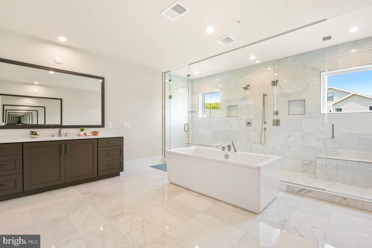12321 Potomac Hunt Road North Potomac, MD 20878 - Photo 45 of 64 a spacious bathroom with a tub sink shower and mirror