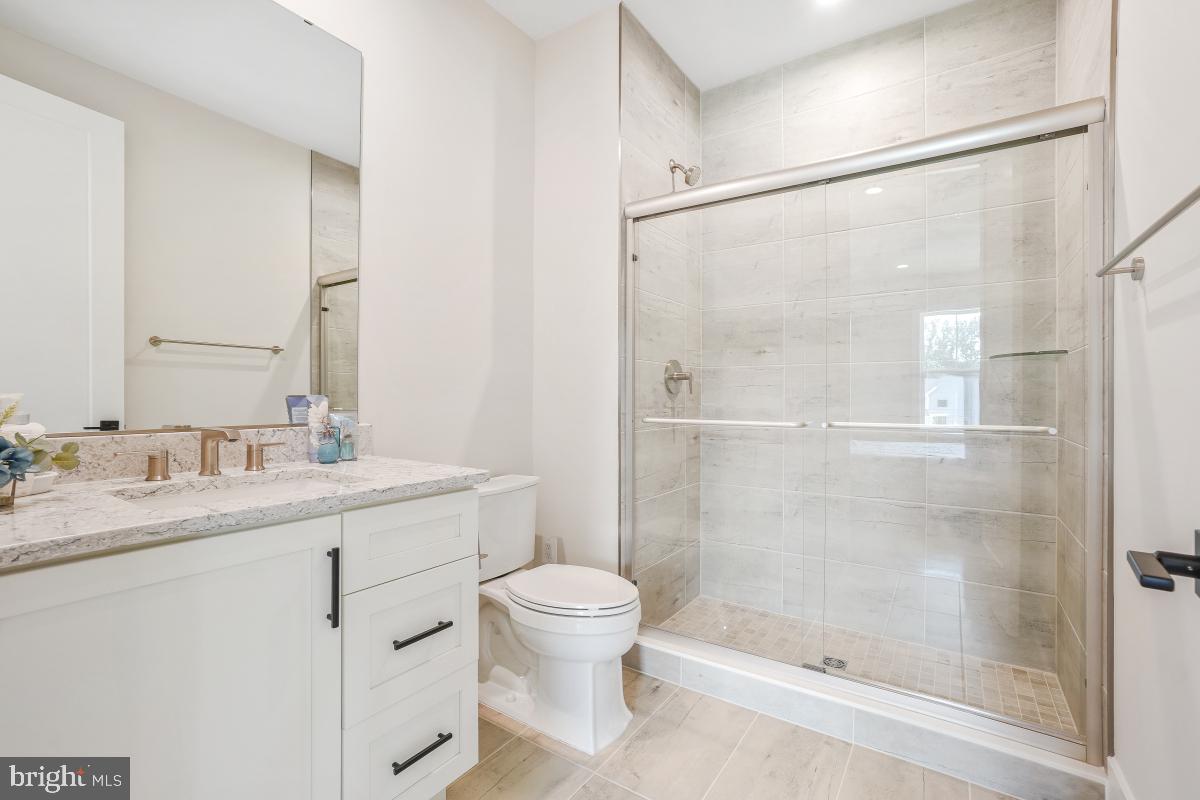 12321 Potomac Hunt Road North Potomac, MD 20878 - Photo 52 of 64 a bathroom with a granite countertop sink a toilet and shower