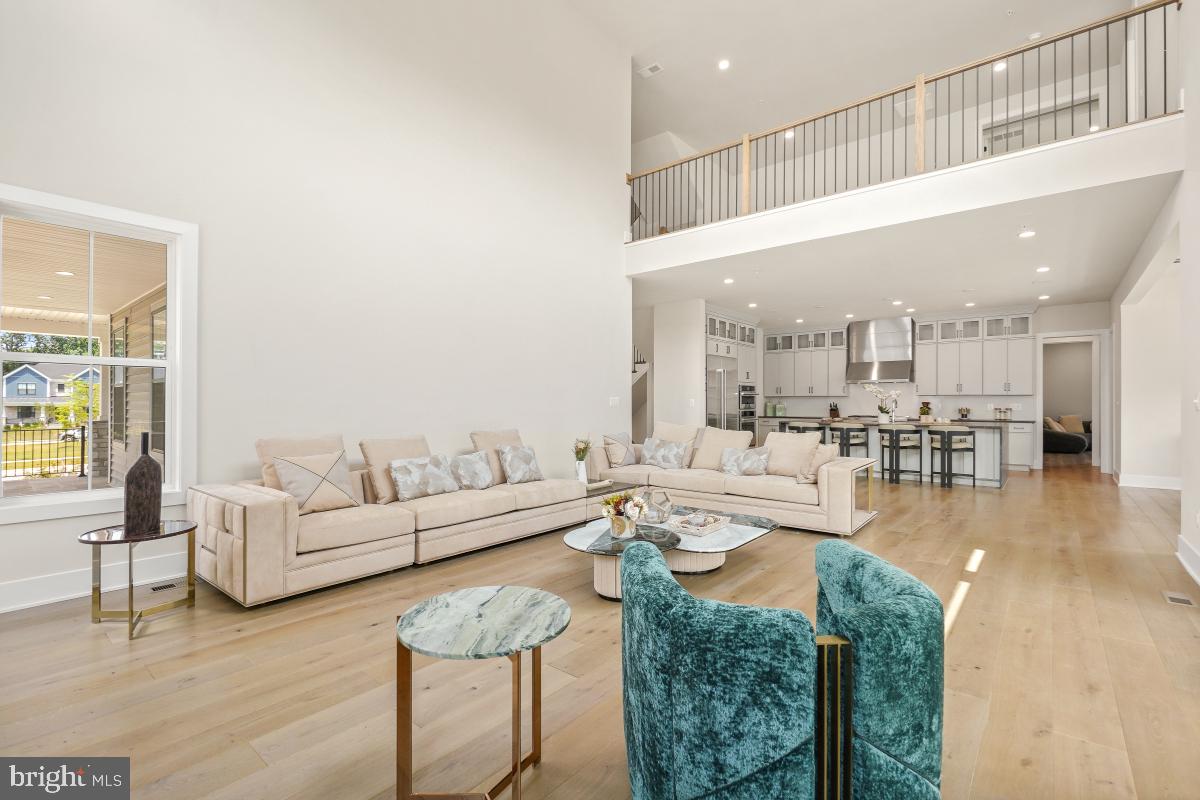 12321 Potomac Hunt Road North Potomac, MD 20878 - Photo 9 of 64 a living room with couches a coffee table and kitchen view with wooden floor