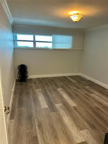 a view of a room with wooden floor and a window