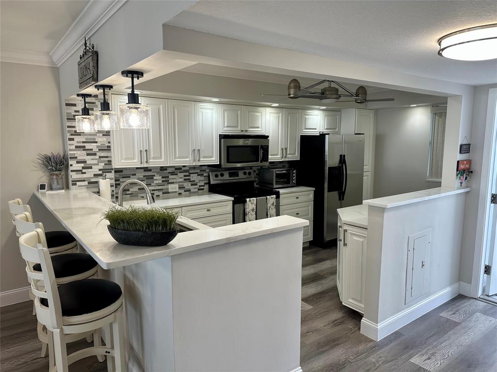 1012 North Ocean Boulevard, Unit 1206 Pompano Beach, FL 33062 - Photo 2 of 33 a kitchen with a sink stainless steel appliances and cabinets