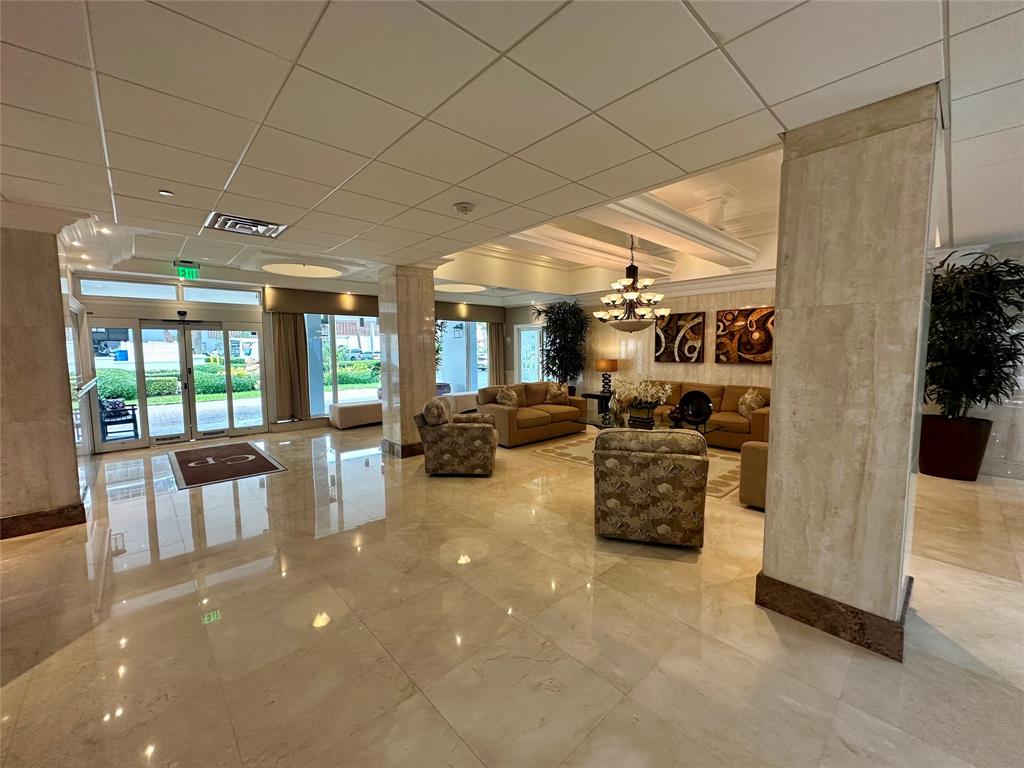 1012 North Ocean Boulevard, Unit 1206 Pompano Beach, FL 33062 - Photo 23 of 33 a living room with furniture and a chandelier