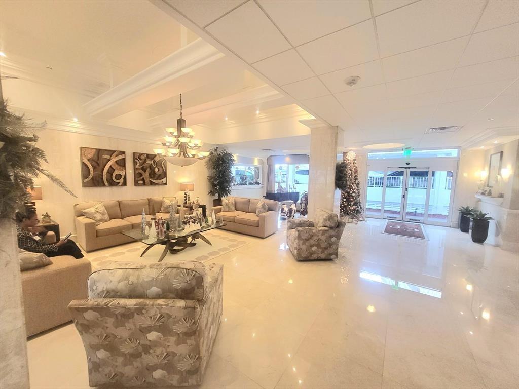 1012 North Ocean Boulevard, Unit 1206 Pompano Beach, FL 33062 - Photo 24 of 33 a very nice looking room with a large mirror and chandelier