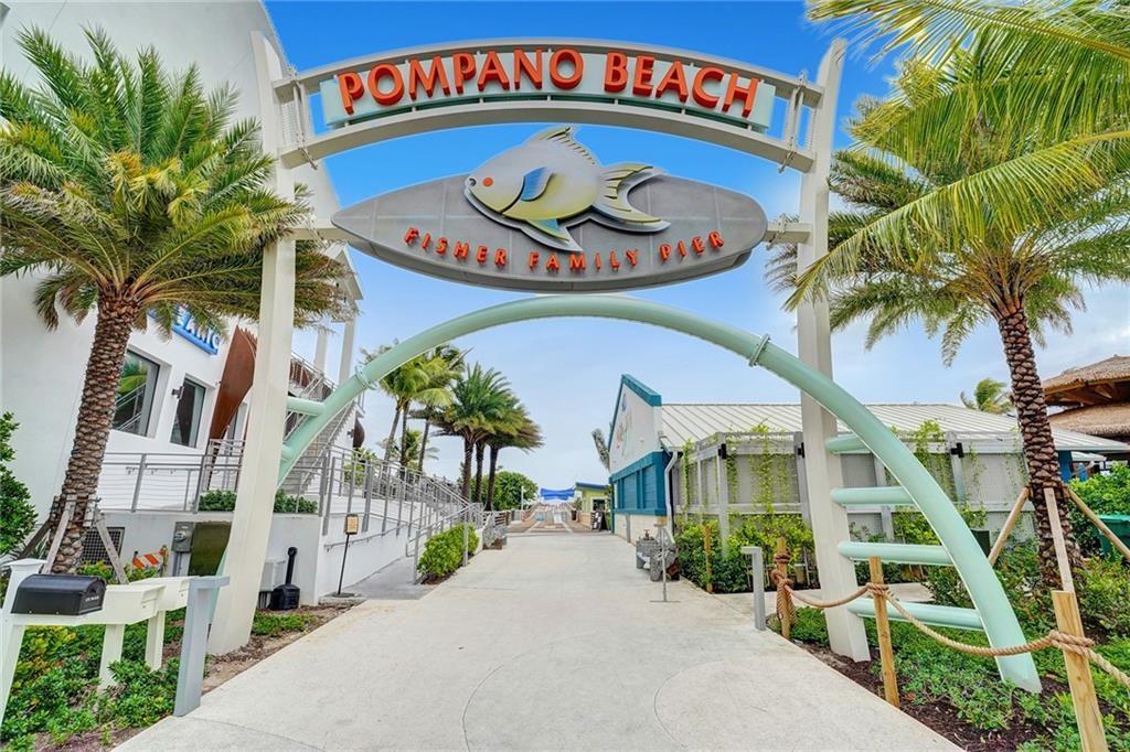 1012 North Ocean Boulevard, Unit 1206 Pompano Beach, FL 33062 - Photo 33 of 33 a front view of multi story residential apartment building with yard and sign board