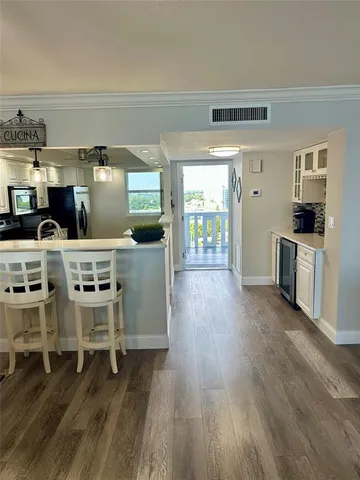 a open kitchen with stainless steel appliances wooden floors and wooden cabinets