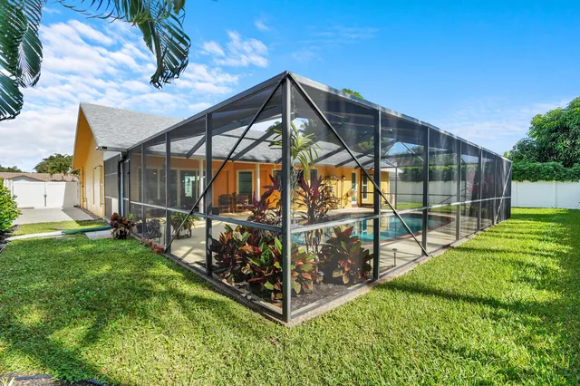 a view of a house with a big yard and potted plants