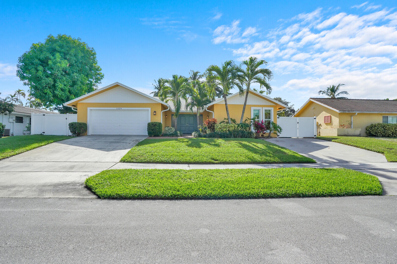 1224 Northwest 15th Street Boca Raton, FL 33486 - Photo 5 of 46 a front view of a house with a yard and garage