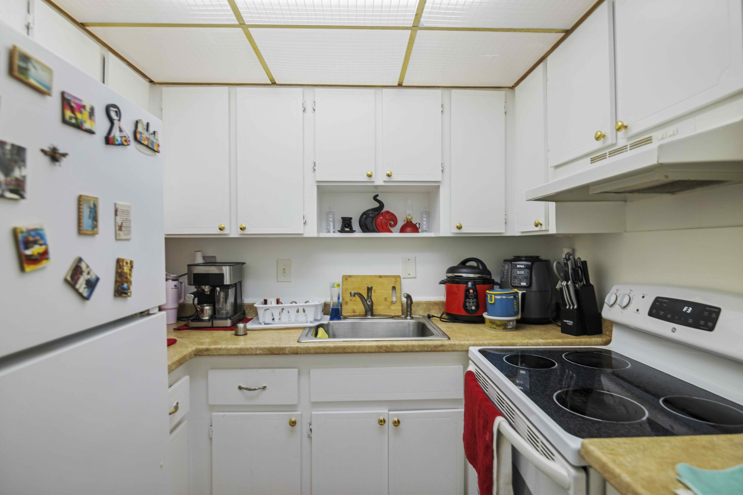 1545 Miami Road Fort Lauderdale, FL 33316 - Photo 23 of 39 a kitchen with white cabinets and white appliances