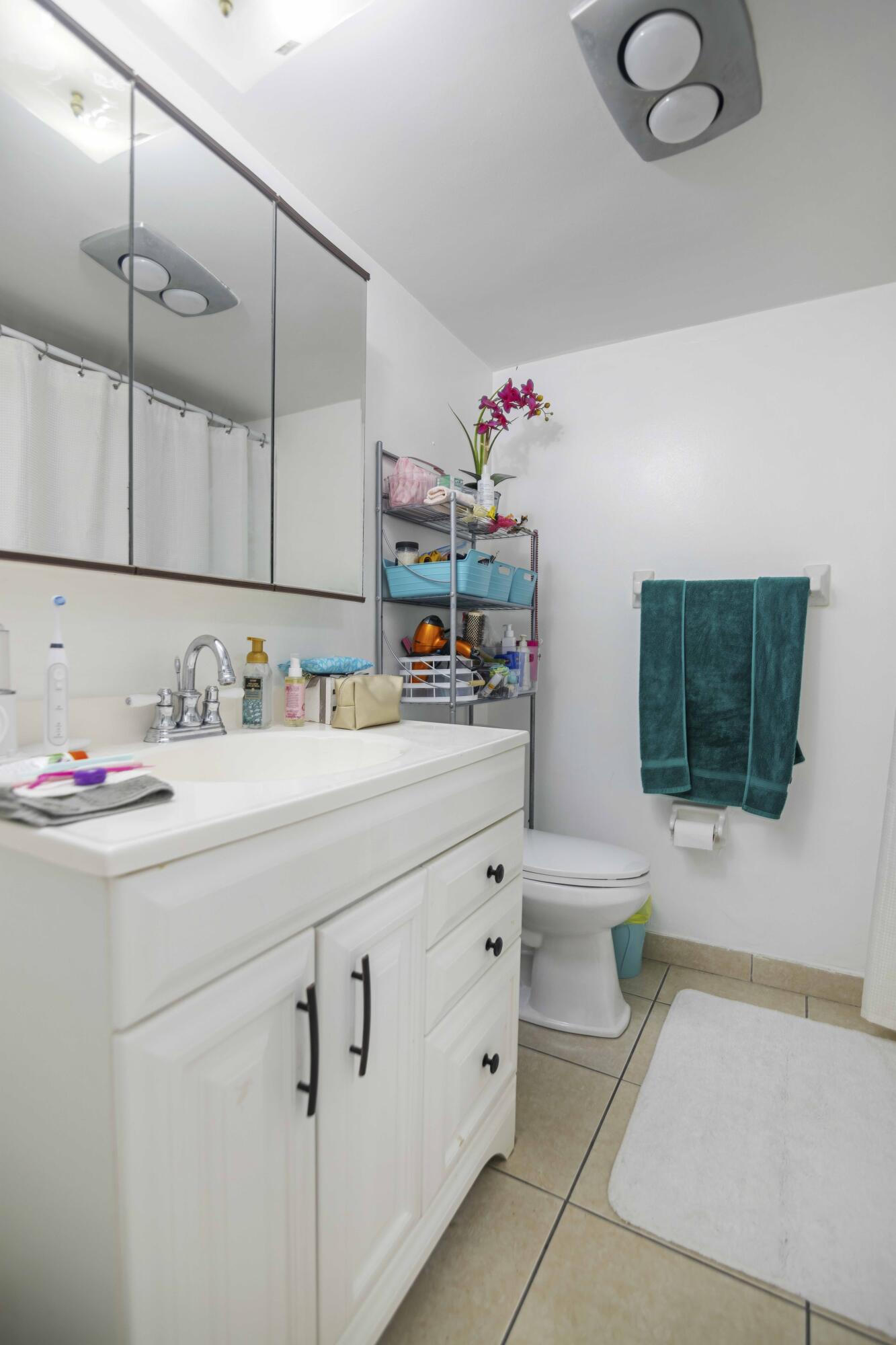 1545 Miami Road Fort Lauderdale, FL 33316 - Photo 29 of 39 a hallway with a mirror a couch and a potted plant