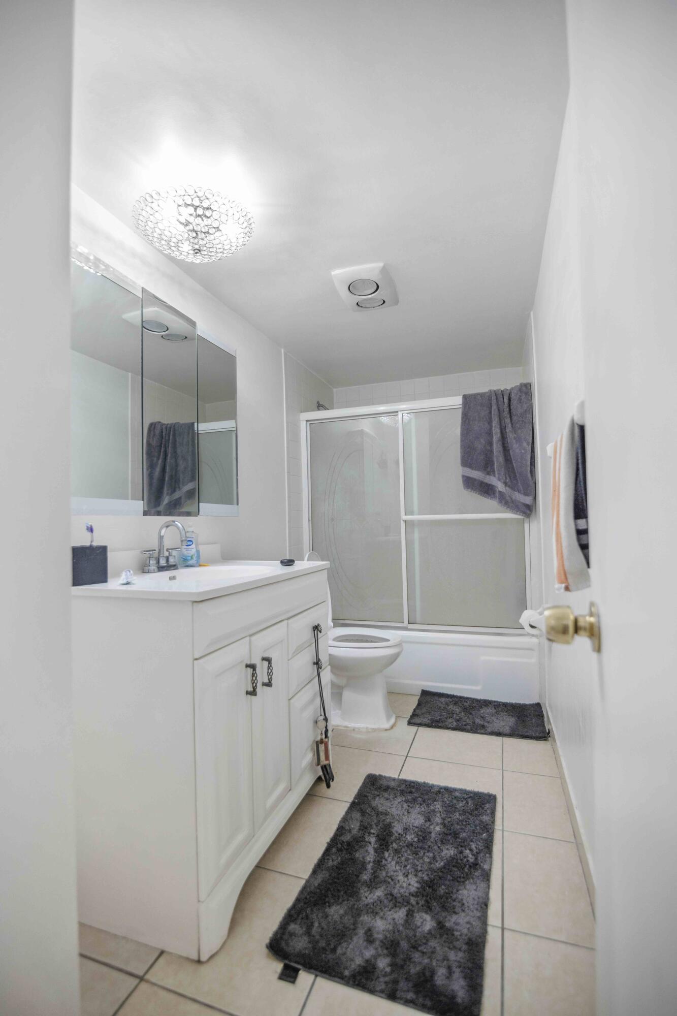 1545 Miami Road Fort Lauderdale, FL 33316 - Photo 35 of 39 a bathroom with a sink a toilet and mirror