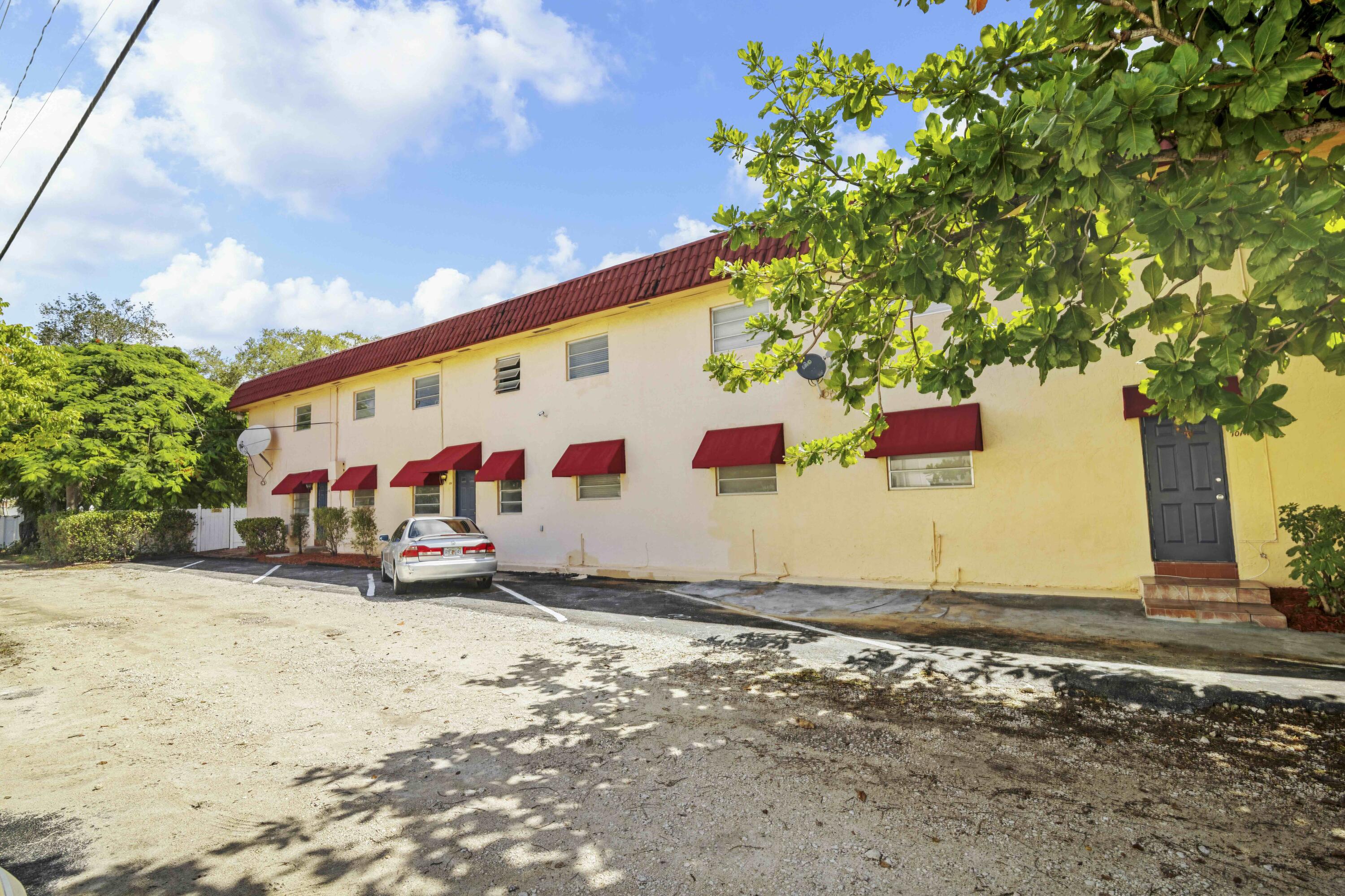 1545 Miami Road Fort Lauderdale, FL 33316 - Photo 6 of 39 a view of a white house with large tree and wooden fence