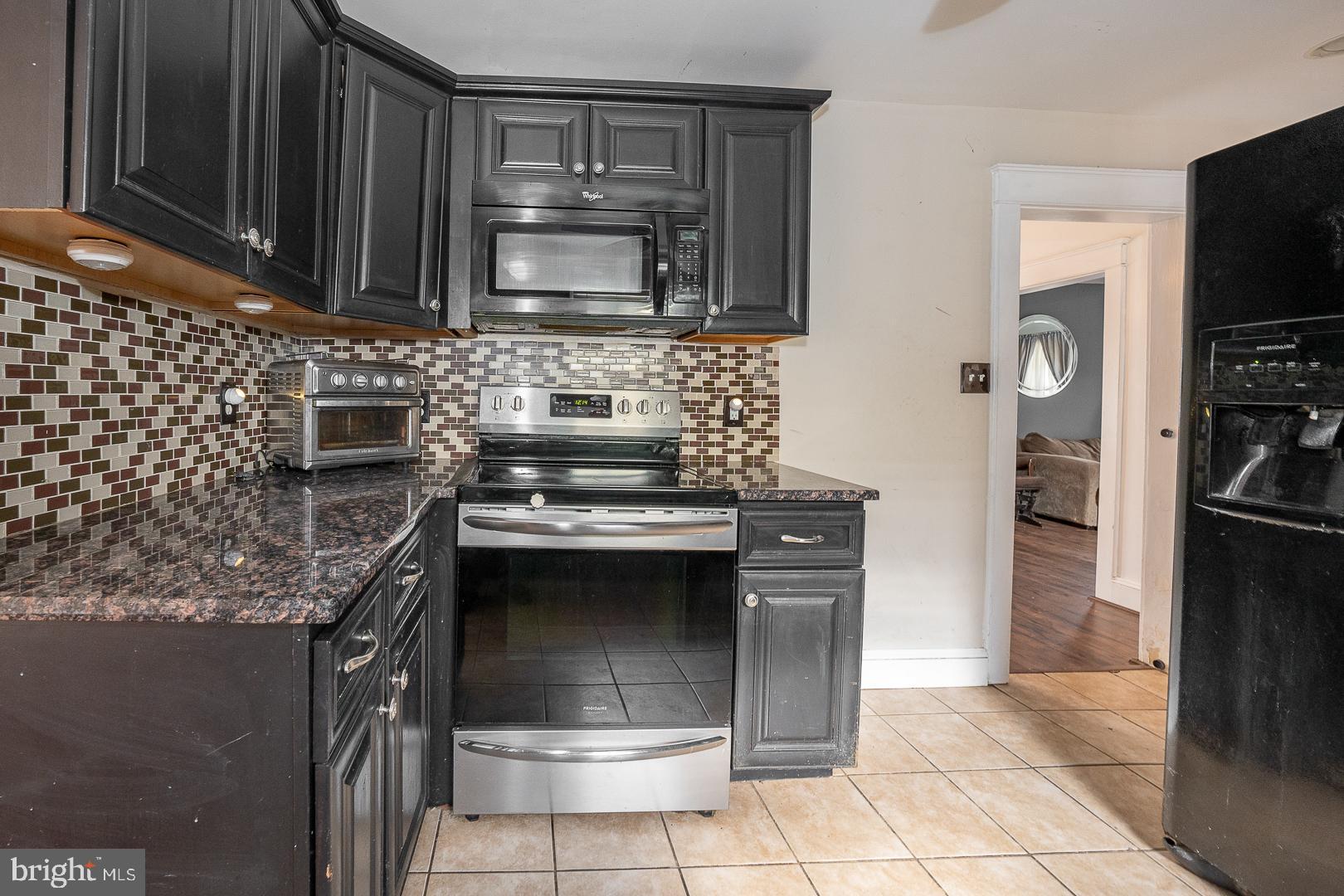 22 Delmont Road Newtown Square, PA 19073 - Photo 15 of 35 a kitchen with stainless steel appliances granite countertop a stove microwave and refrigerator