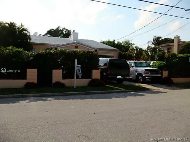a couple of cars parked in front of a house