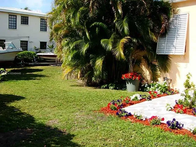 a front view of a house with a yard and fountain