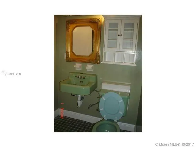 a bathroom with a toilet mirror and vanity