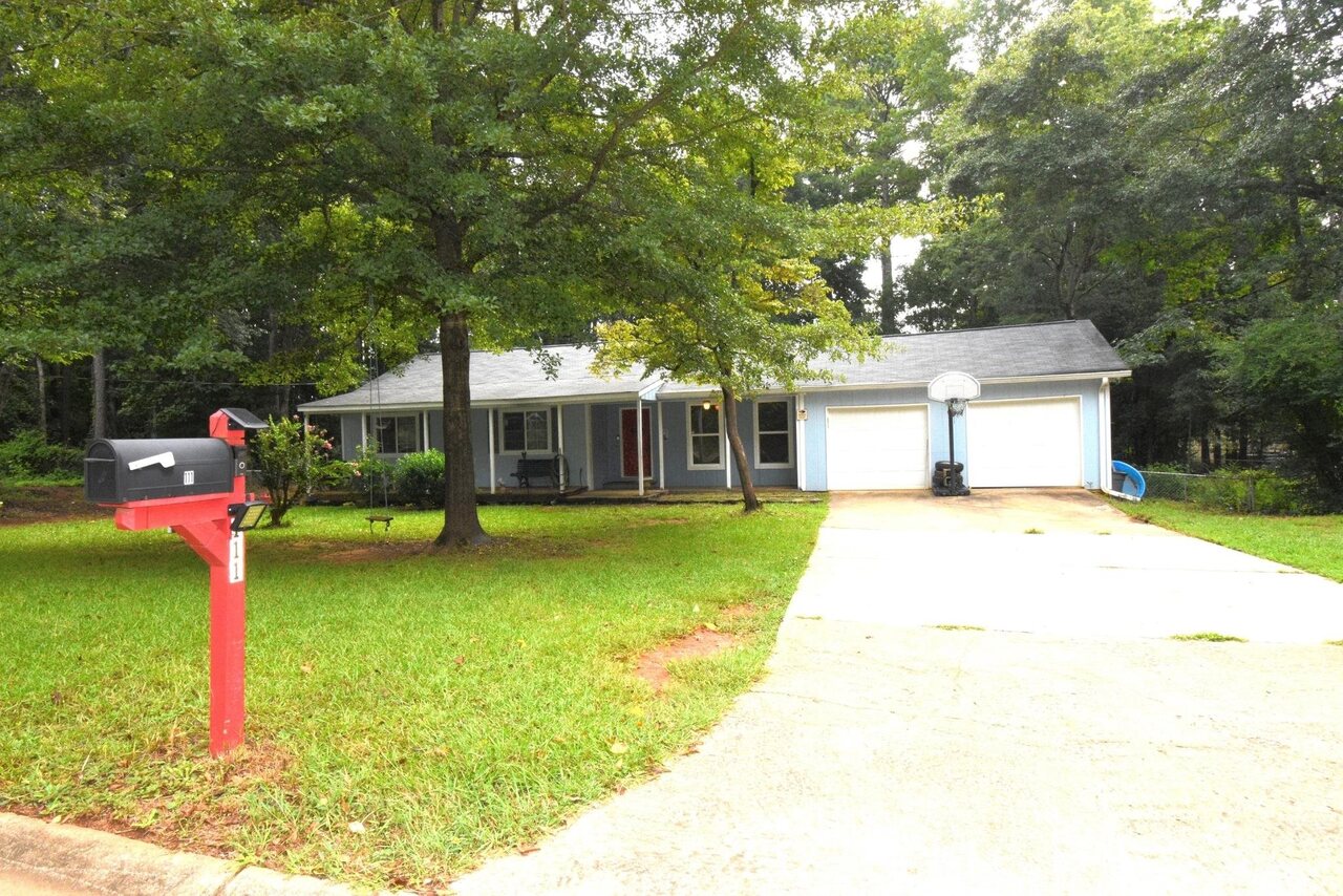 111 Wildwood Road Stockbridge, GA 30281 - Photo 1 of 1 a front view of a house with a garden and trees