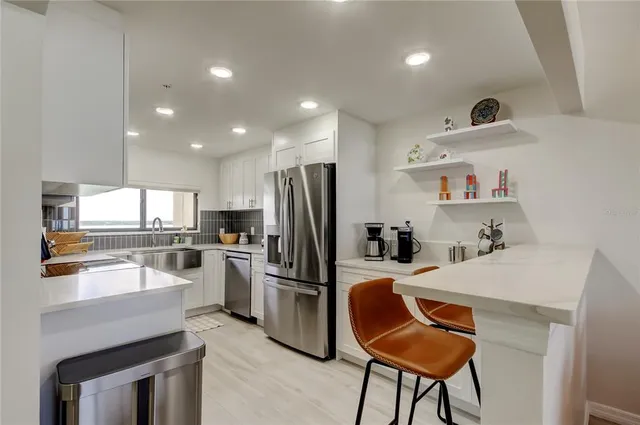 a kitchen with granite countertop a refrigerator stove and oven