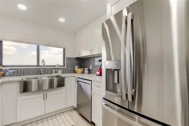 a kitchen with stainless steel appliances a refrigerator sink and cabinets
