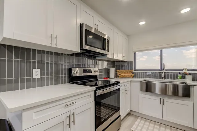 a kitchen with stainless steel appliances a stove sink microwave and cabinets