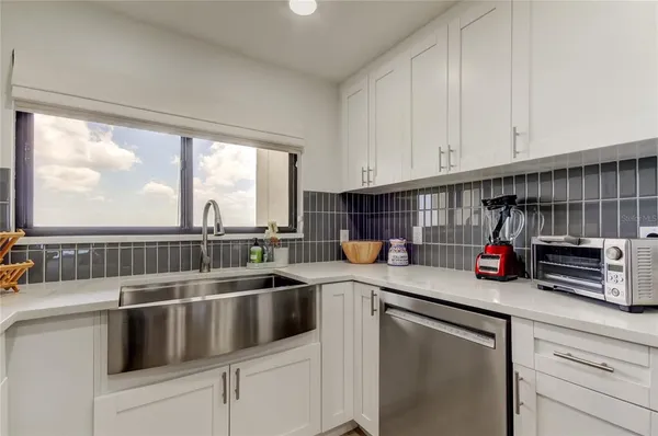 a kitchen with stove a sink and cabinets