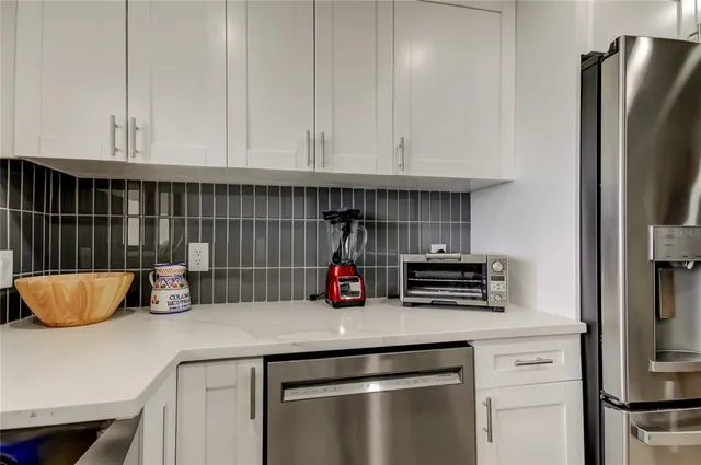 a kitchen with stainless steel appliances granite countertop a refrigerator a stove and a sink