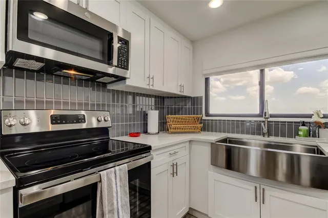 a kitchen with stainless steel appliances granite countertop a stove and a microwave