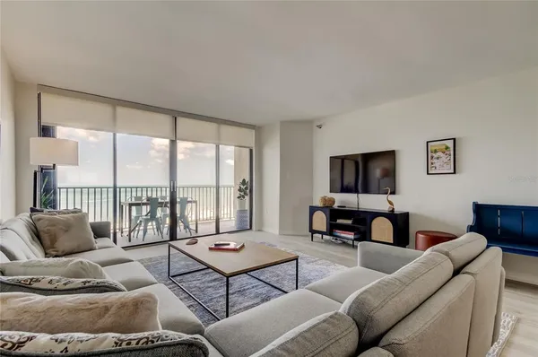 a living room with furniture and a floor to ceiling window