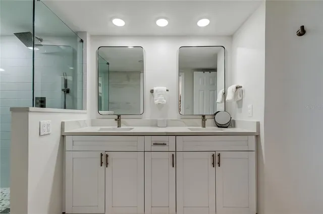 a bathroom with double vanity sinks and a mirror