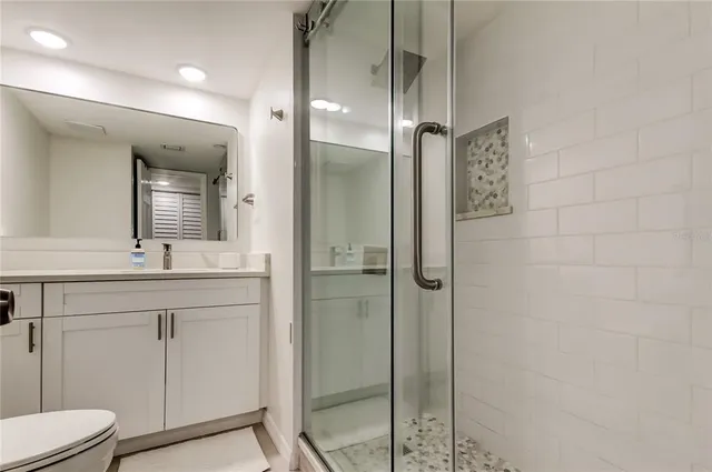 a bathroom with a shower sink and mirror