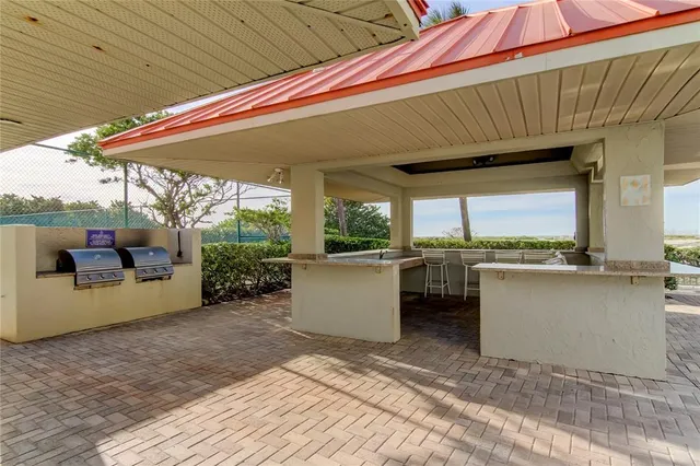 a view of a patio with a table and chairs under an umbrella
