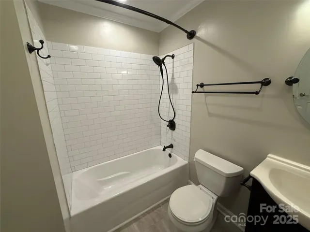 a white toilet sitting next to a bath tub and a shower