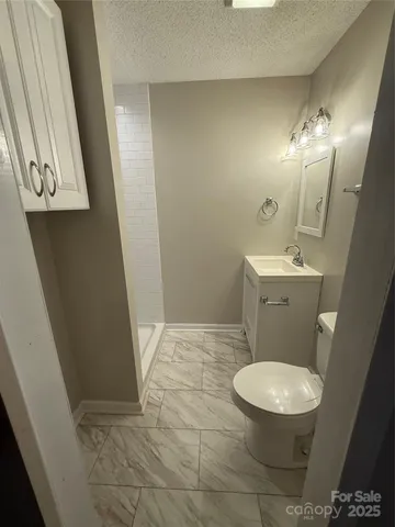 a white toilet sitting next to a bathroom sink and a mirror