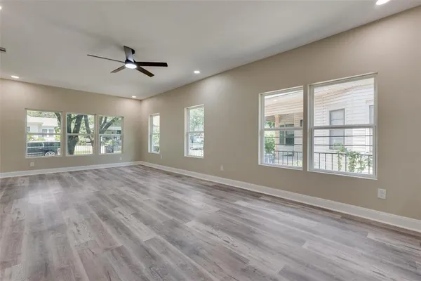 a view of an empty room with a window and wooden floor
