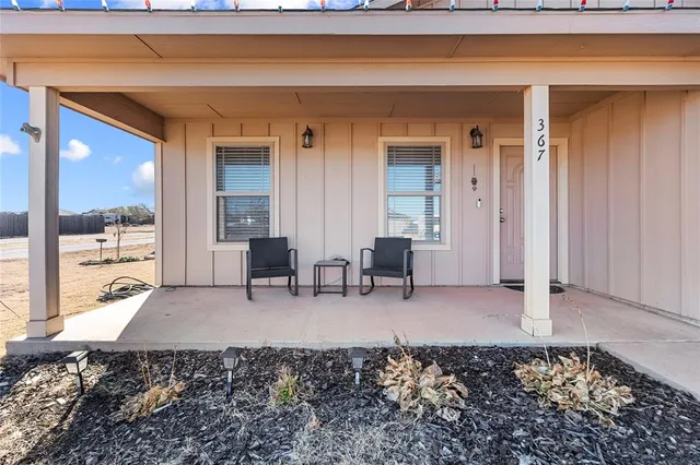 a living room with furniture and large windows