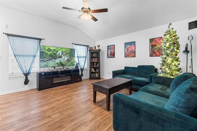 a living room with furniture a window and a flat screen tv