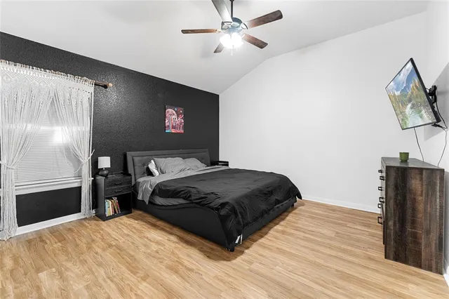 a bedroom with a bed and wooden floor