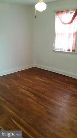 1224 Kevin Road Baltimore, MD 21229 - Photo 6 of 11 a view of an empty room with wooden floor and a window