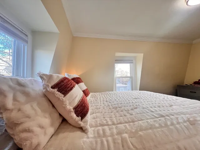 a bed sitting in a bedroom next to a window