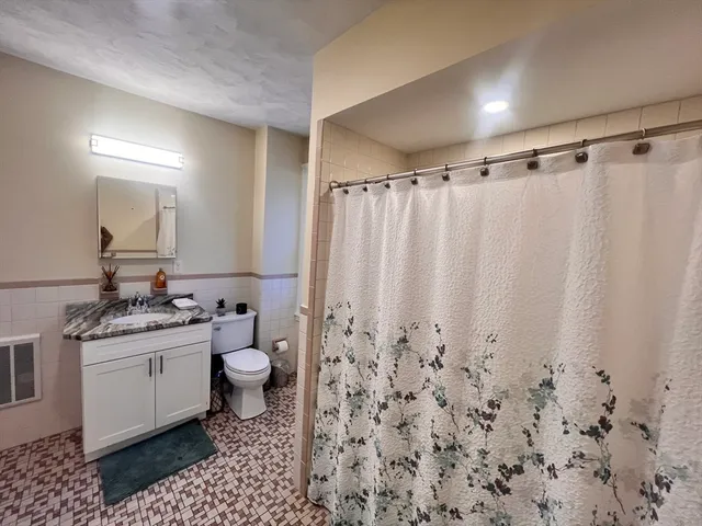 a bathroom with a granite countertop sink toilet and shower