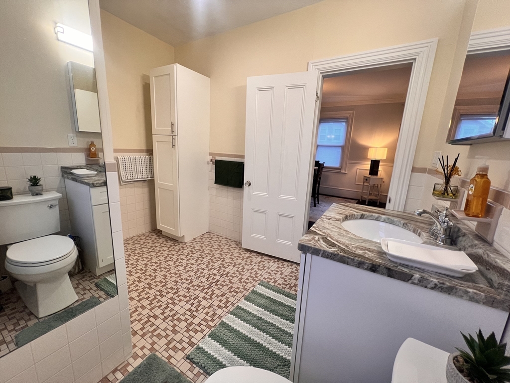 17 Emerson Street, Unit 2 Wakefield, MA 01880 - Photo 20 of 22 a bathroom with a granite countertop toilet sink and mirror