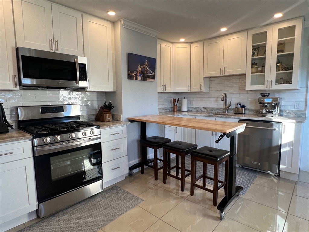17 Emerson Street, Unit 2 Wakefield, MA 01880 - Photo 2 of 22 a kitchen with a stove a sink and a microwave