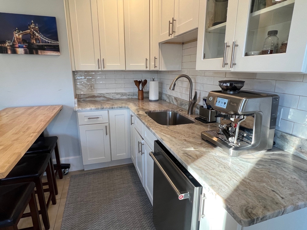 17 Emerson Street, Unit 2 Wakefield, MA 01880 - Photo 3 of 22 a kitchen with granite countertop a sink a stove and cabinets