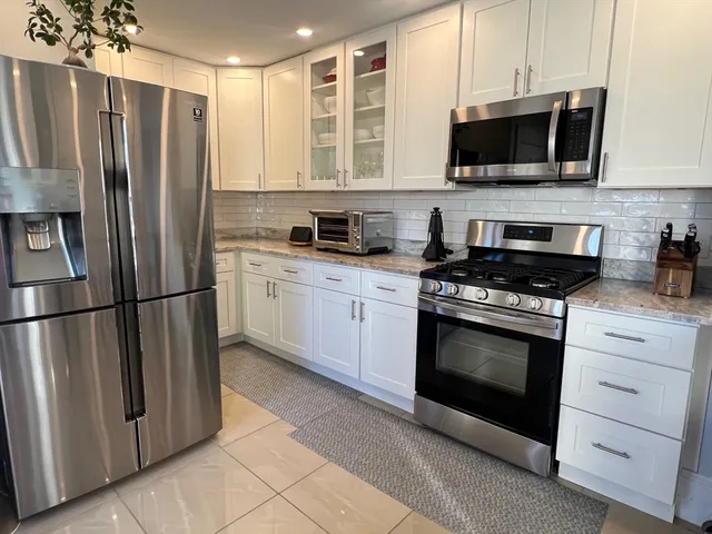 a kitchen with stainless steel appliances a refrigerator sink and microwave
