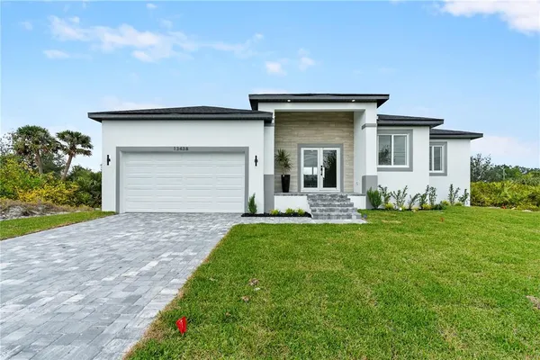 a front view of a house with a garden and yard